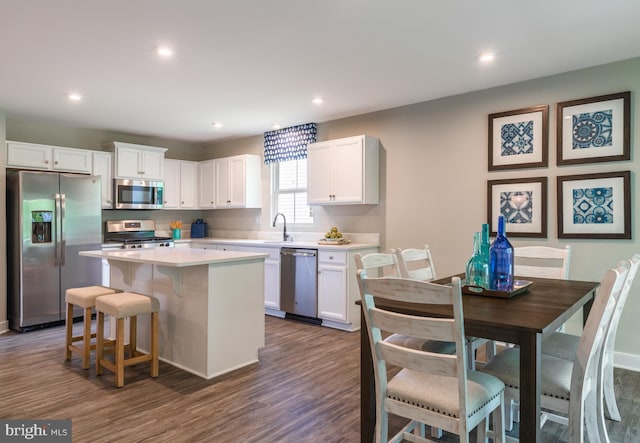 kitchen with white cabinetry, appliances with stainless steel finishes, a center island, and sink