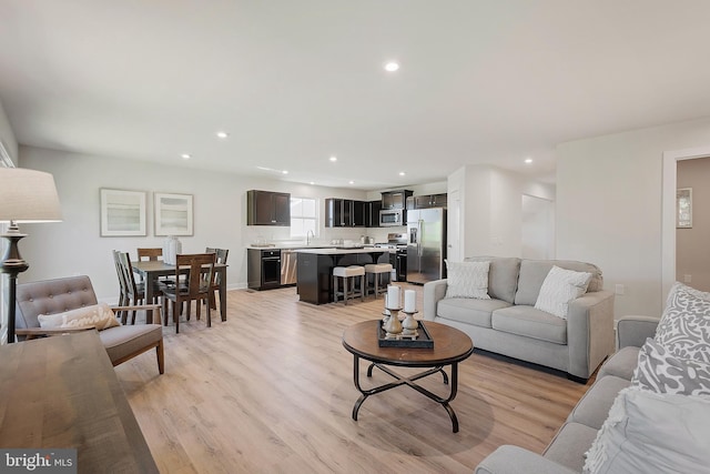 living room with sink and light wood-type flooring