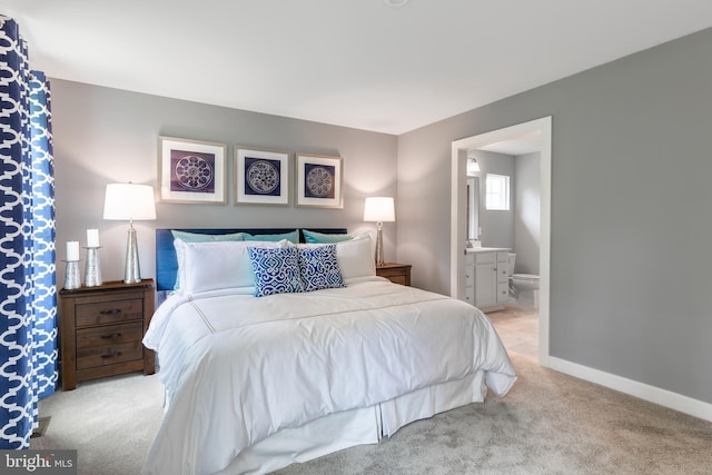 bedroom with light colored carpet and connected bathroom