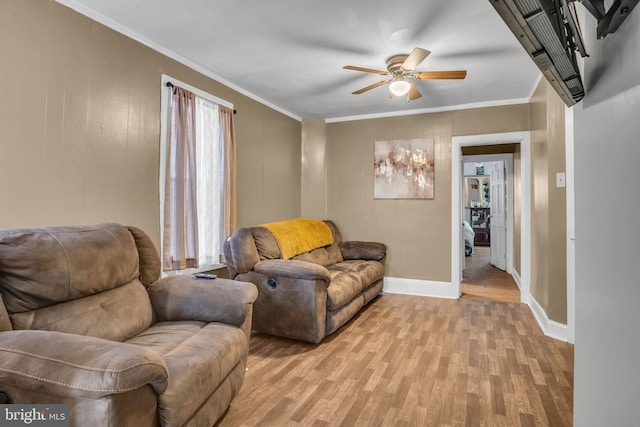 living room with crown molding, ceiling fan, and light hardwood / wood-style flooring