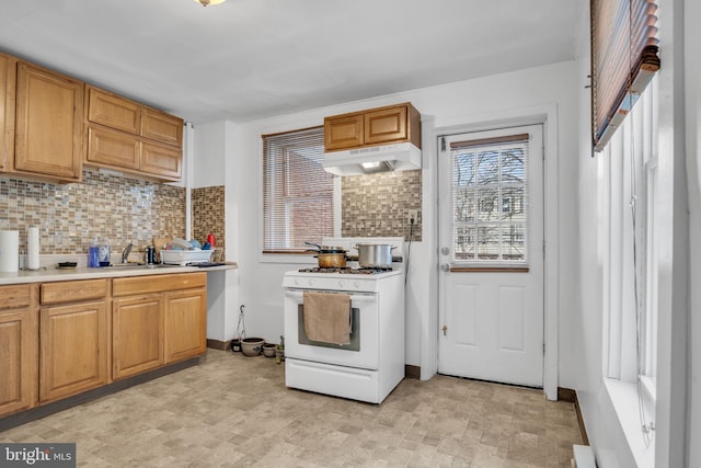 kitchen featuring sink, decorative backsplash, and white gas range oven