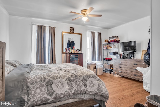 bedroom with hardwood / wood-style flooring, crown molding, and ceiling fan