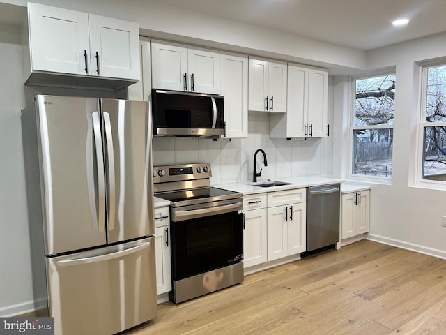 kitchen featuring white cabinetry, stainless steel appliances, light hardwood / wood-style floors, and sink