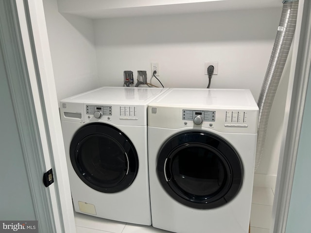 laundry area with washing machine and dryer and light tile patterned flooring