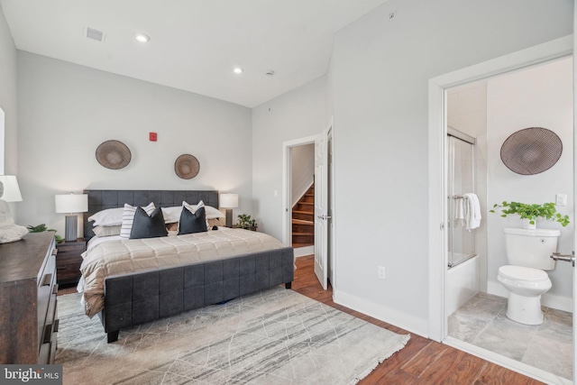 bedroom with connected bathroom and light hardwood / wood-style floors