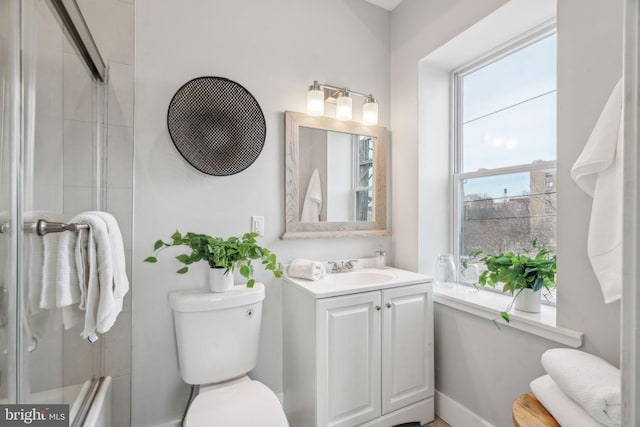 bathroom featuring vanity, an enclosed shower, and toilet