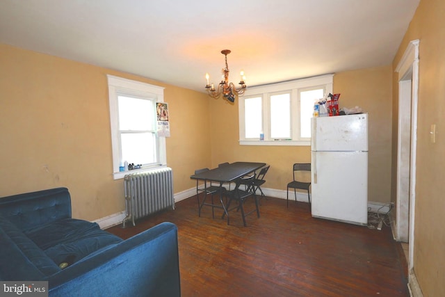 dining area featuring dark wood-type flooring, radiator, plenty of natural light, and baseboards