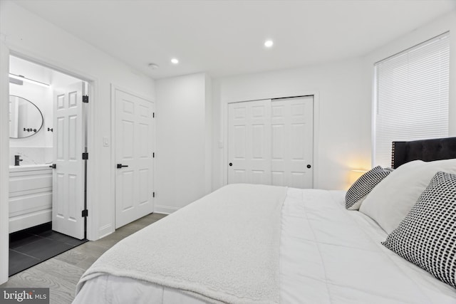 bedroom featuring dark wood-type flooring, recessed lighting, a closet, and ensuite bathroom