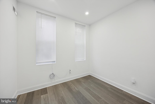 spare room featuring recessed lighting, visible vents, dark wood finished floors, and baseboards