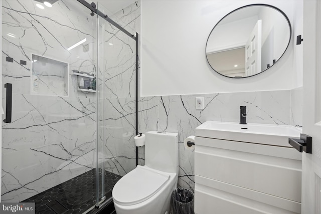 bathroom featuring tile walls, a marble finish shower, vanity, and toilet