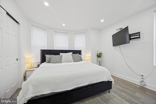 bedroom featuring baseboards, wood finished floors, and recessed lighting