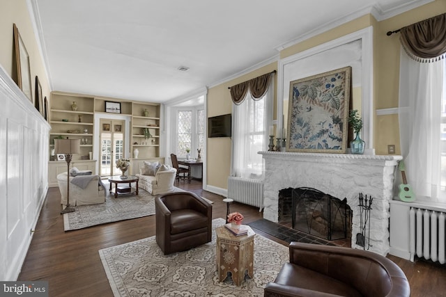 living area featuring radiator, crown molding, and wood finished floors