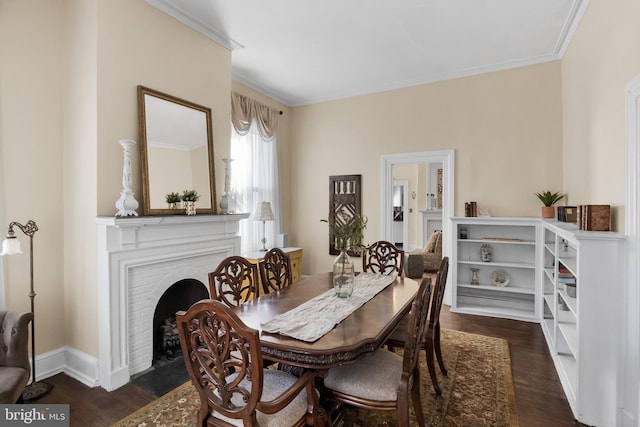 dining room featuring ornamental molding, a brick fireplace, dark wood finished floors, and baseboards