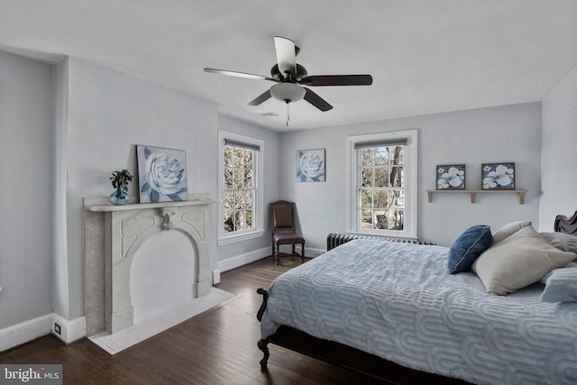 bedroom featuring visible vents, baseboards, a ceiling fan, radiator, and wood finished floors