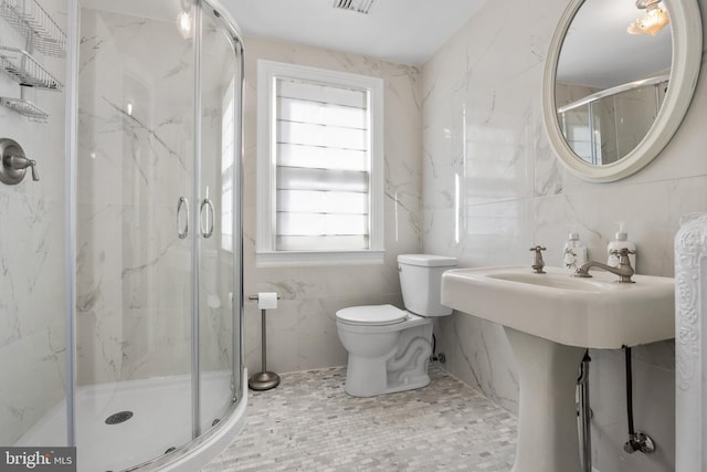 bathroom with visible vents, a marble finish shower, toilet, and tile walls