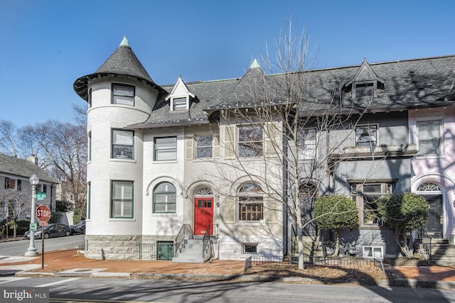 view of front of house with entry steps and a high end roof