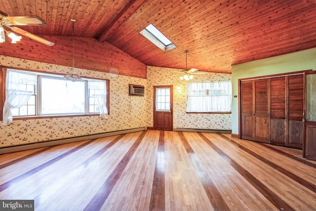 interior space with ceiling fan, wood-type flooring, lofted ceiling with skylight, and a baseboard heating unit