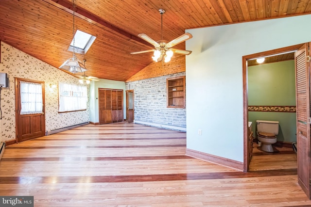 spare room featuring a baseboard radiator, vaulted ceiling with skylight, wooden ceiling, and light hardwood / wood-style flooring