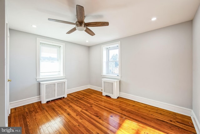 unfurnished room featuring wood-type flooring, radiator, and ceiling fan