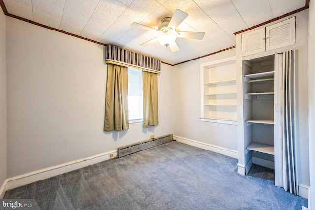 carpeted spare room featuring ornamental molding, ceiling fan, built in features, and baseboard heating