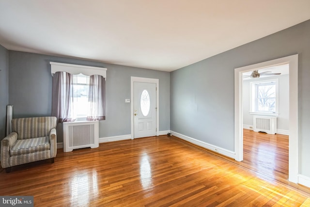 entrance foyer with hardwood / wood-style flooring and radiator heating unit