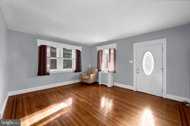 foyer entrance featuring radiator and hardwood / wood-style floors