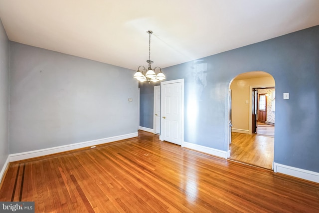 unfurnished room featuring light hardwood / wood-style floors and a notable chandelier