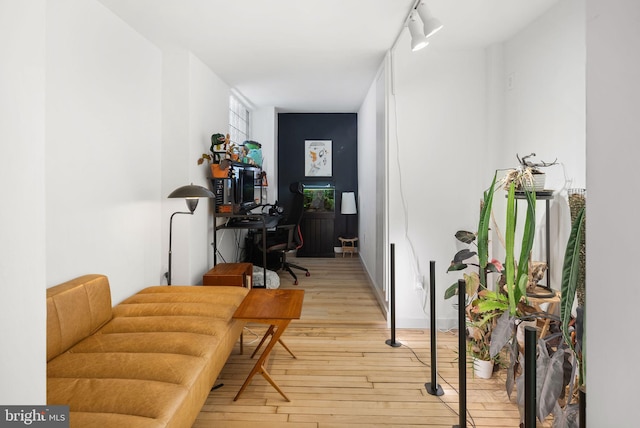 hall featuring track lighting and light hardwood / wood-style floors