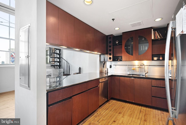 kitchen with plenty of natural light, appliances with stainless steel finishes, sink, and light wood-type flooring