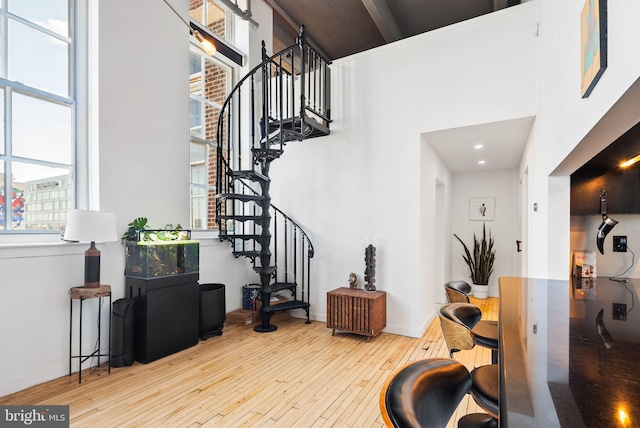 foyer featuring a towering ceiling and light hardwood / wood-style flooring