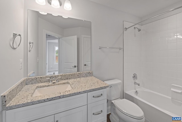 full bathroom featuring vanity, tiled shower / bath combo, and toilet