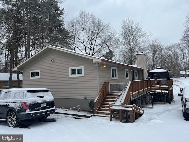 snow covered rear of property featuring a gazebo, stairway, and a wooden deck