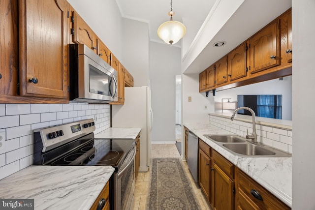 kitchen featuring sink, tasteful backsplash, crown molding, hanging light fixtures, and appliances with stainless steel finishes