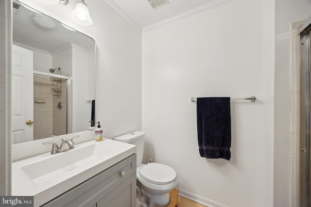 bathroom with ornamental molding, toilet, a shower with door, and vanity