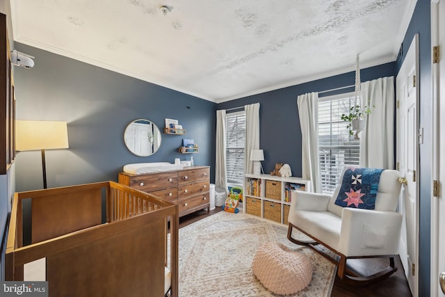 bedroom with hardwood / wood-style floors and a nursery area