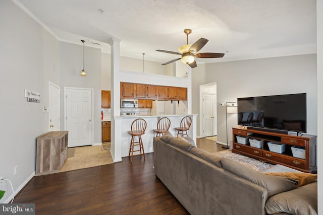 living room with ceiling fan, high vaulted ceiling, and light hardwood / wood-style floors