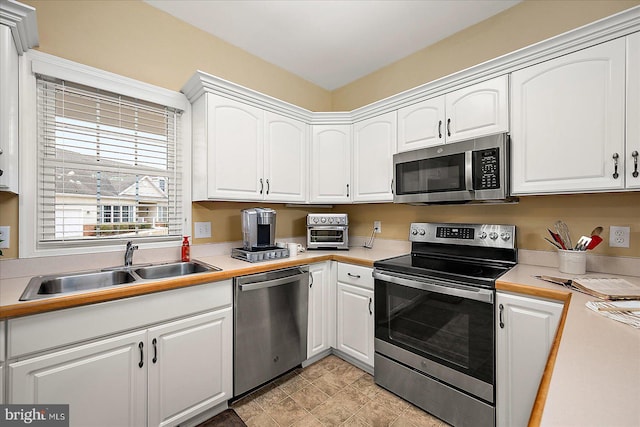 kitchen with white cabinetry, sink, and stainless steel appliances