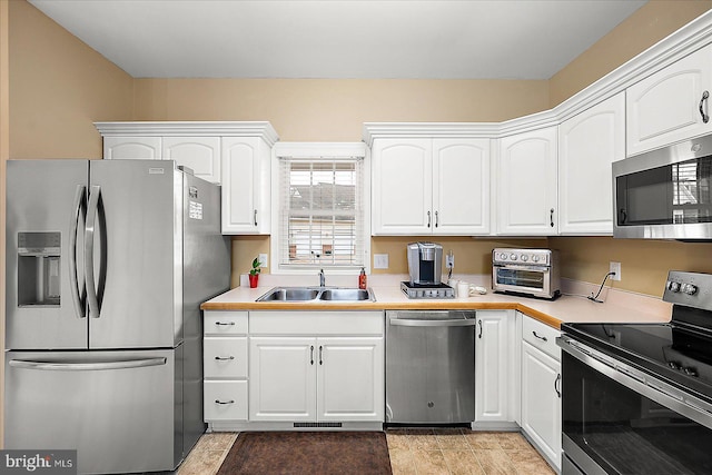 kitchen with white cabinetry, sink, and stainless steel appliances