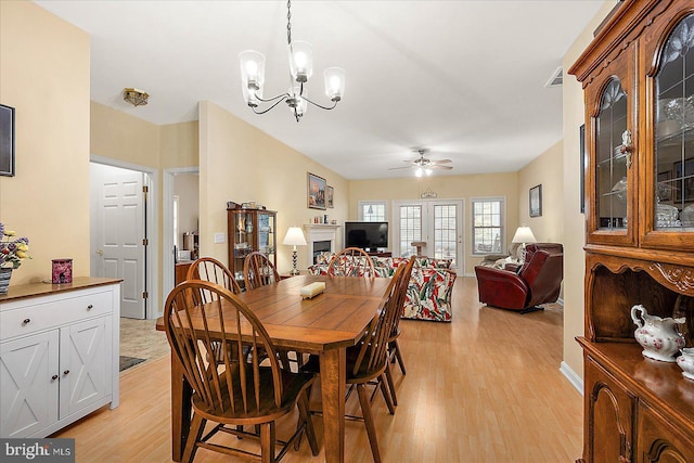 dining room featuring ceiling fan with notable chandelier and light wood-type flooring