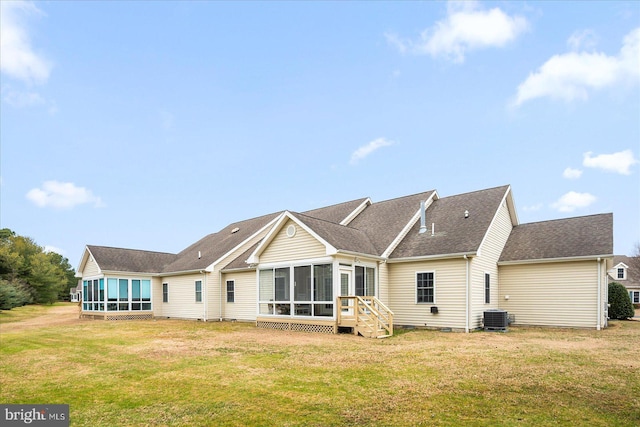 rear view of property featuring cooling unit, a yard, and a sunroom