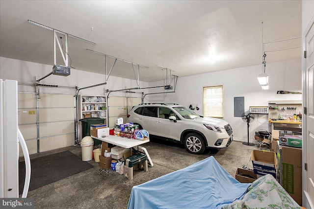 garage featuring white refrigerator, a garage door opener, and electric panel