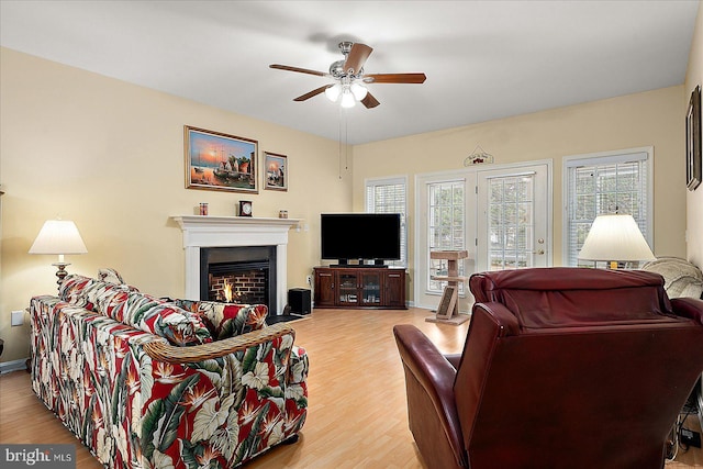 living room featuring a wealth of natural light, ceiling fan, and light wood-type flooring