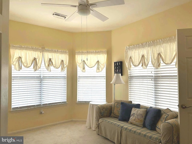 living room featuring a ceiling fan, carpet, visible vents, and baseboards