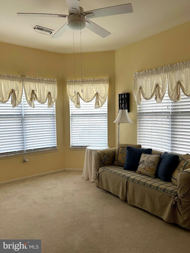 living area with ceiling fan, carpet, visible vents, and baseboards