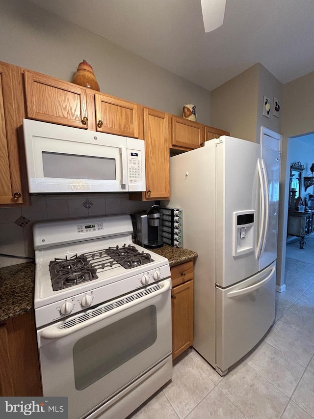 kitchen featuring light tile patterned floors, white appliances, and brown cabinetry