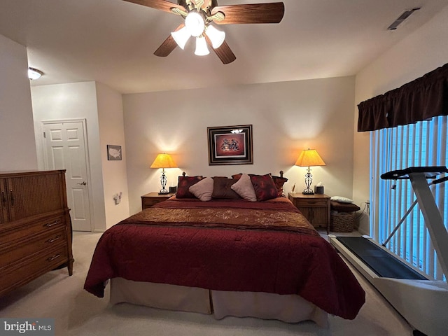 bedroom featuring a ceiling fan, light colored carpet, and visible vents