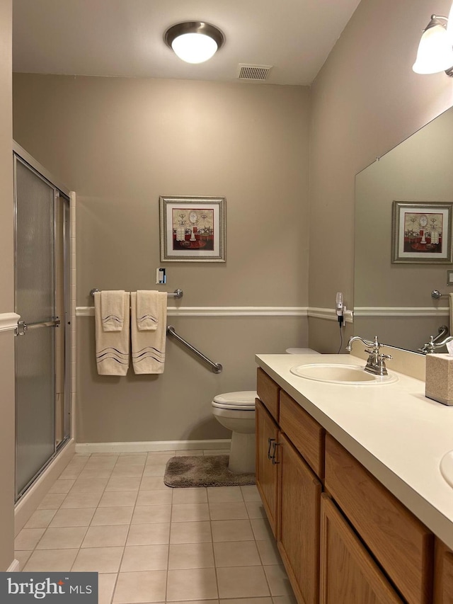 bathroom with double vanity, visible vents, a sink, a shower stall, and tile patterned floors