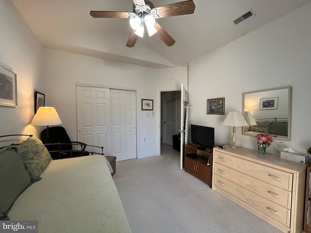 interior space featuring visible vents, a ceiling fan, light colored carpet, vaulted ceiling, and a closet