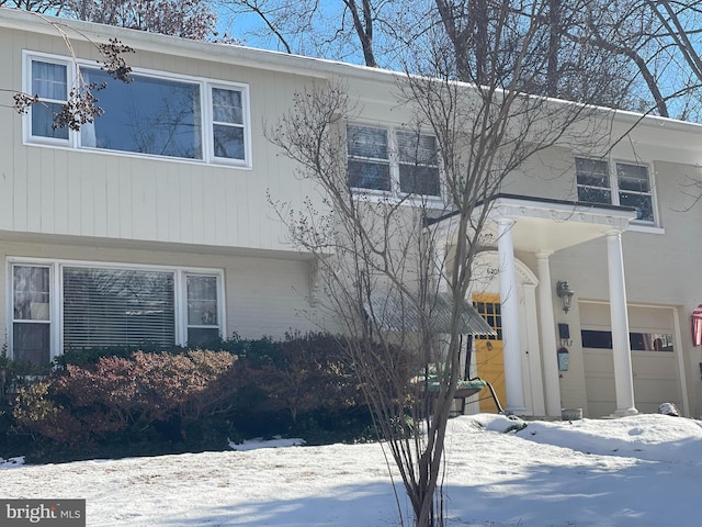 view of snow covered exterior featuring a garage