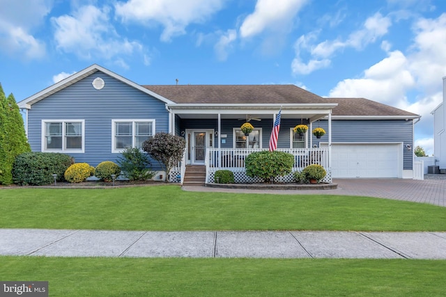 single story home featuring a porch, a garage, and a front yard